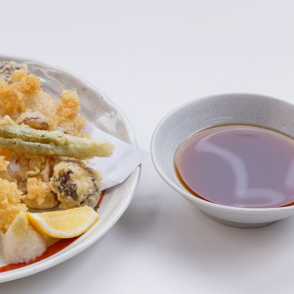 En skål med tentsuyu, i sidan av tempura, japansk tempurasås med en balanserad smak av soja och dashi