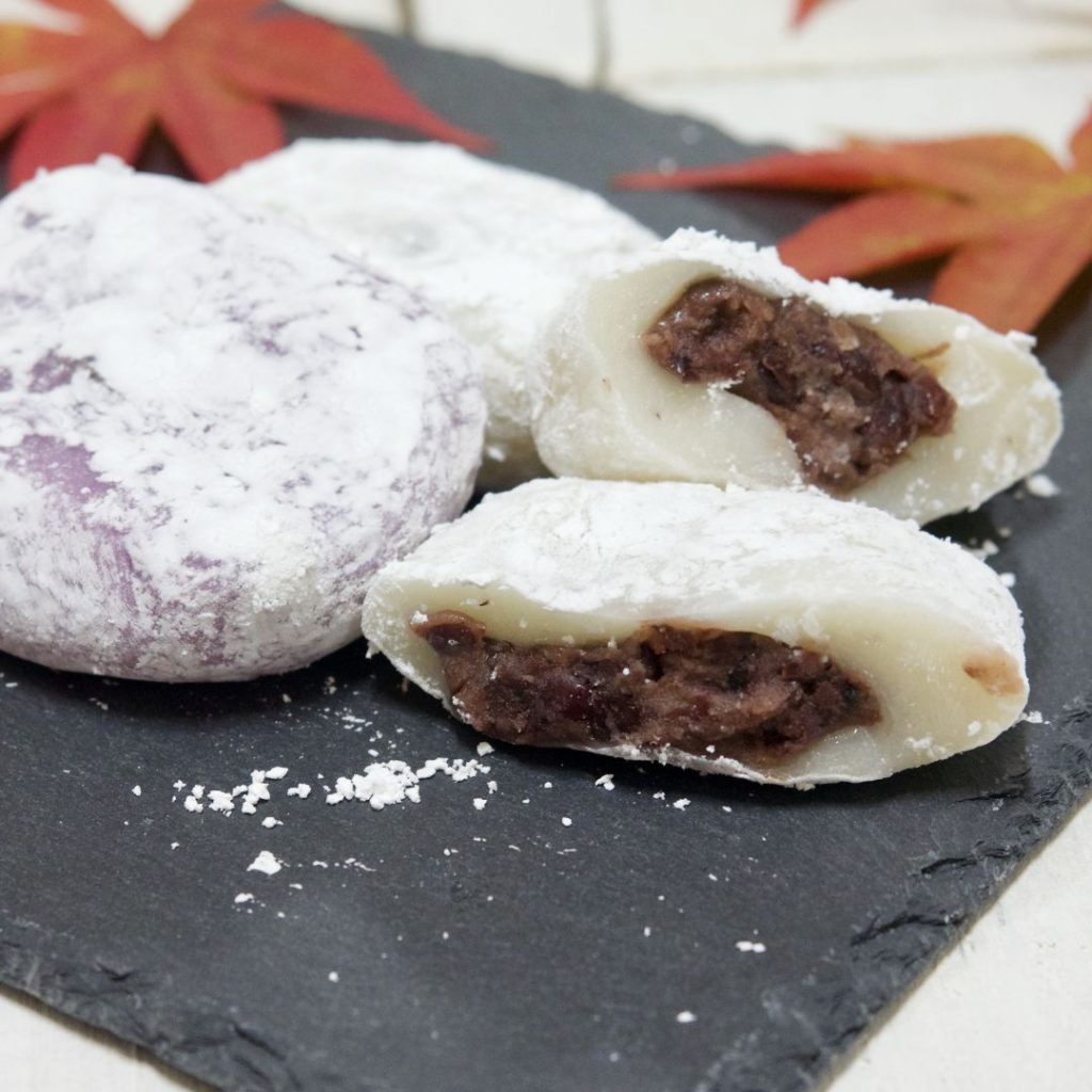 En stentallrik med koreanska chapssaltteok, klibbiga riskakor fyllda med söt bönpasta, en populär festlig godsak