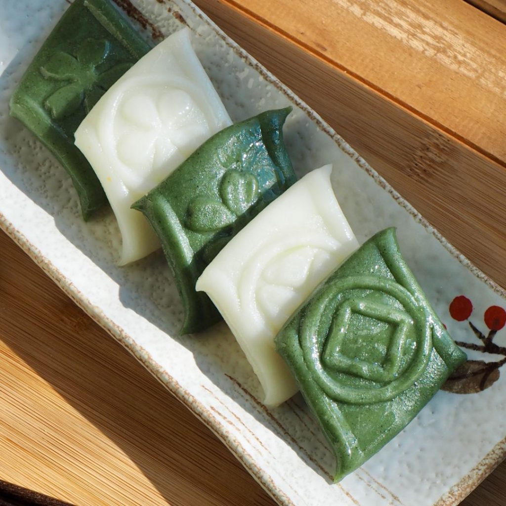 En tallrik med Jeolpyeon, traditionella koreanska riskakor i dekorativa mönster, serverade på ett fat som en festlig dessert