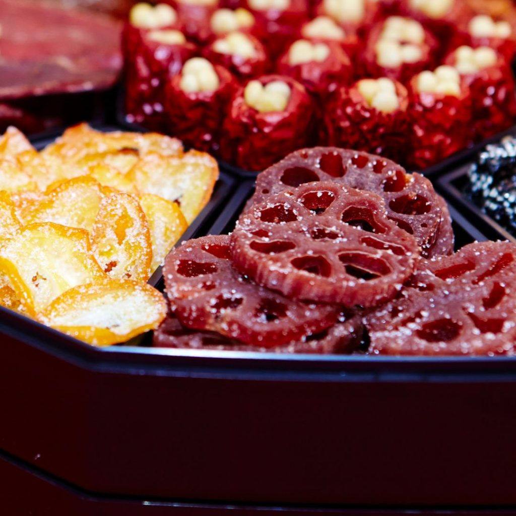 Ett fat med yeongeun-jeonggwa, glaserad och karamelliserad lotusrot, vackert arrangerad som en traditionell koreansk dessert