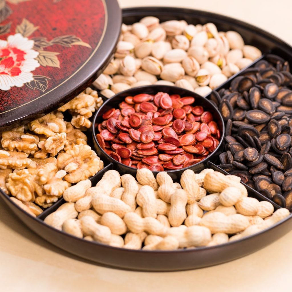 Ett kinesiskt nyårssnackfat fyllt med godsaker och nötter som symboliserar goda önskningar