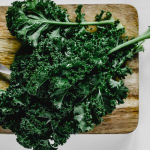 En hög av färsk grönkål med krusiga blad, rik på näring och perfekt för sallader, smoothies och matlagning.