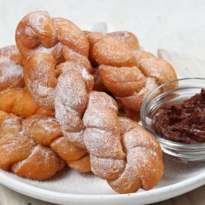 En tallrik med koreanska kkwabaegi, mjuka och fluffiga friterade munkar med en söt kanelsockerbeläggning