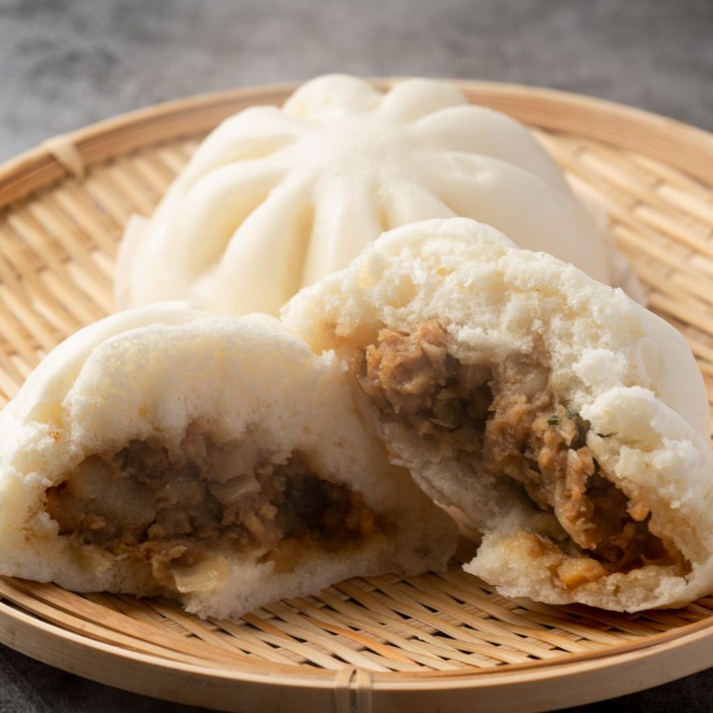 Fluffiga japanska nikuman, ångade bröd fyllda med saftig köttfärs, en populär street food-snack