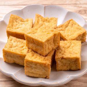 Gyllene bitar av atsuage, friterad tofu med en krispig yta och mjuk insida, ofta använd i japansk matlagning.