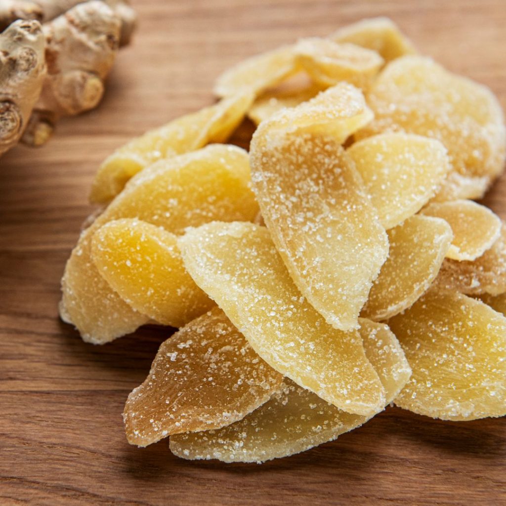 Kanderad ingefära, en söt och kryddig delikatess där ingefärsbitar kokas i sockerlag och torkas för en karamelliserad yta