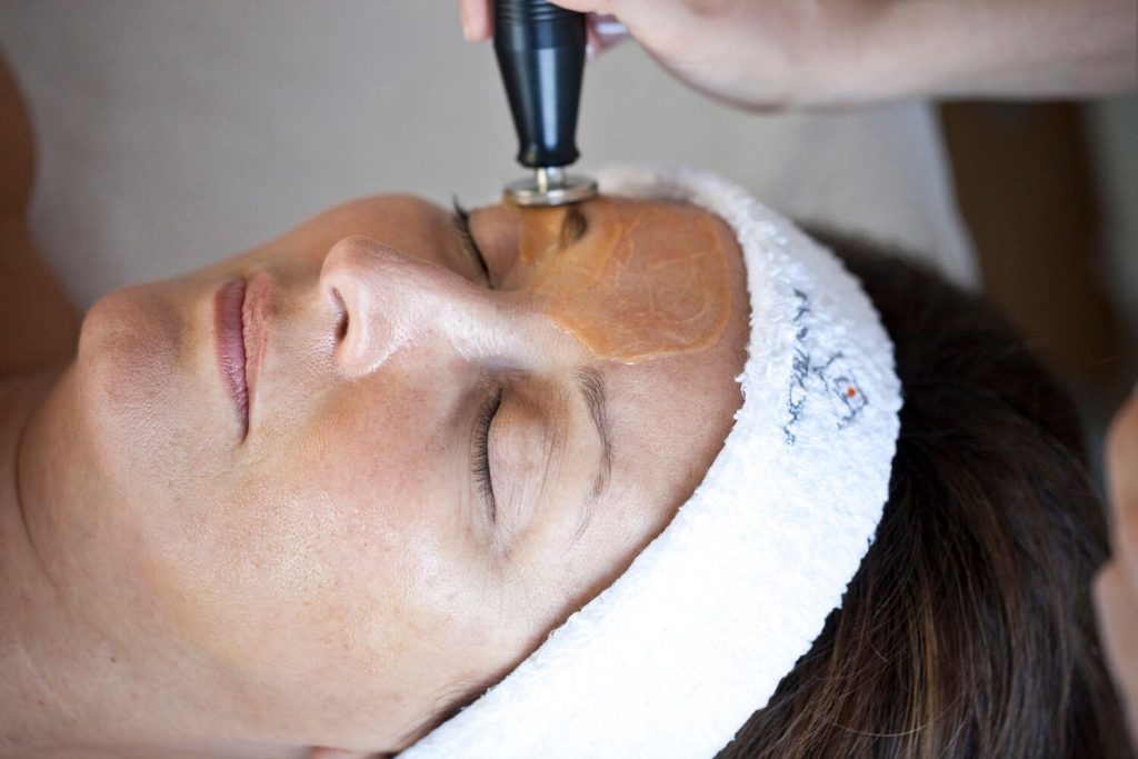 ENVIRON® Electrosonic Dual Frequency probe being applied to a woman's forehead.