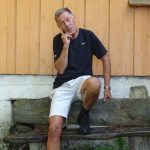 Her sitter jeg på en benk utenfor huset til den store dikter og skribent fra Surnadal på Nordmøre.