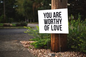 Stam met bord 'You Are Worthy of Love'