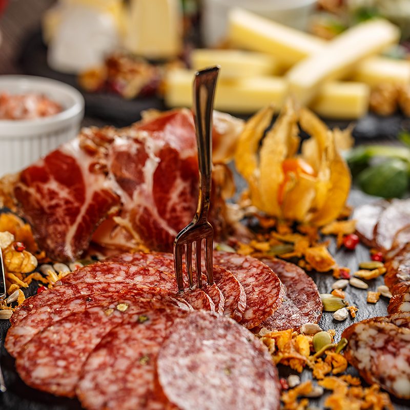 Cutting sausage and cured meat on a celebratory table