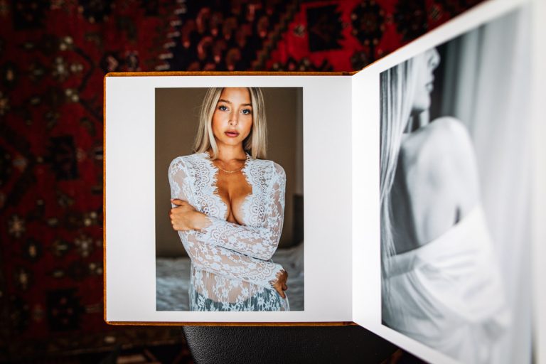 Fotobok med boudoirbilder på en blond kvinna i vit spetsklänning