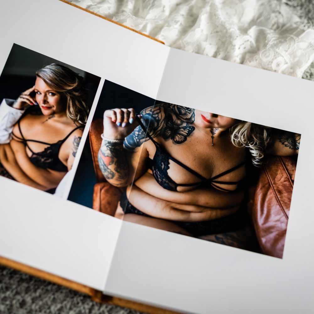 Fotoalbum ligger öppet med ett uppslag av två boudoirfoton på en plus size kvinna i underkläder