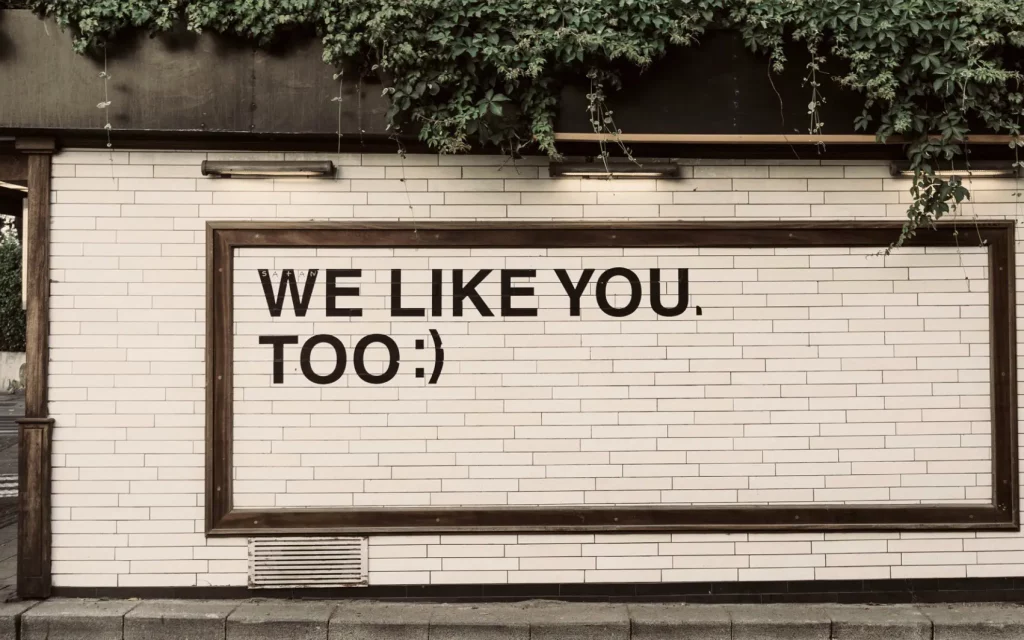 Hauswand mit der Aufschrift "We Like You, Too :)"