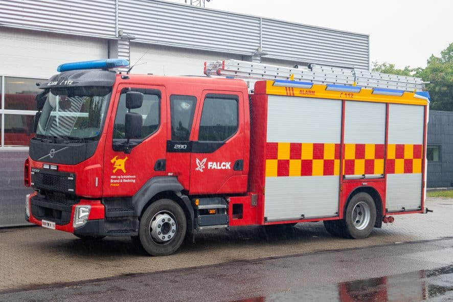 Midt- og Sydsjællands Brand & Redning station Prestø. Volvo FL sprøjte foran stationen i silende regn.