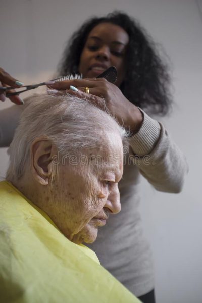 black-girl-cuts-hair-to-old-white-woman-caregiver-elderly-caucasian-142608753 black-girl-cuts-hair-to-old-white-woman-caregiver-elderly-caucasian-142608753