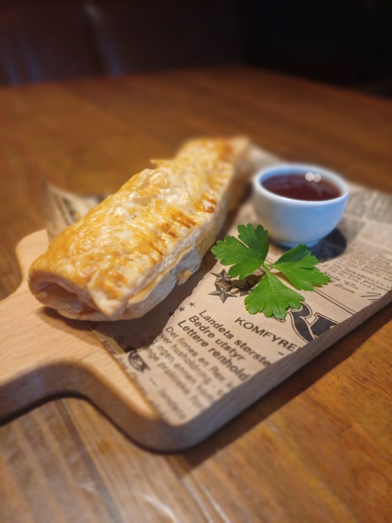 Sausage roll served with brown sauce