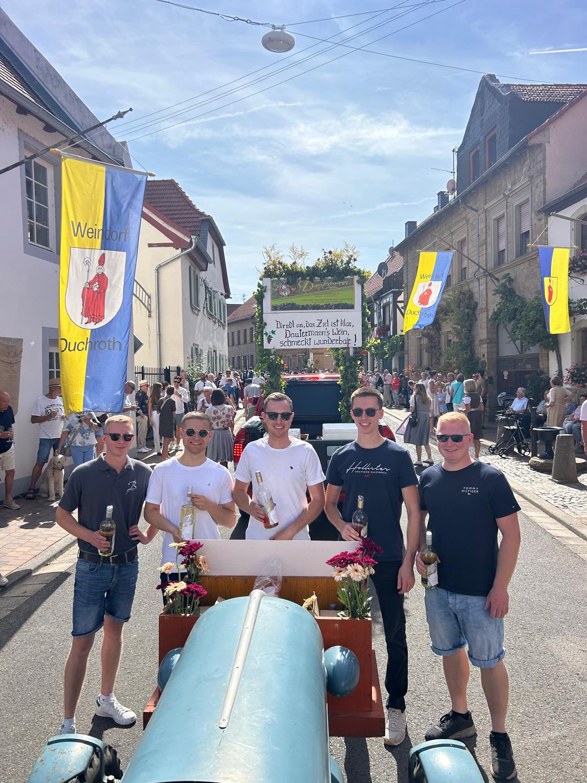 Jungs vom Buchenländerhof mit Weinflaschen bei dem Festumzug
