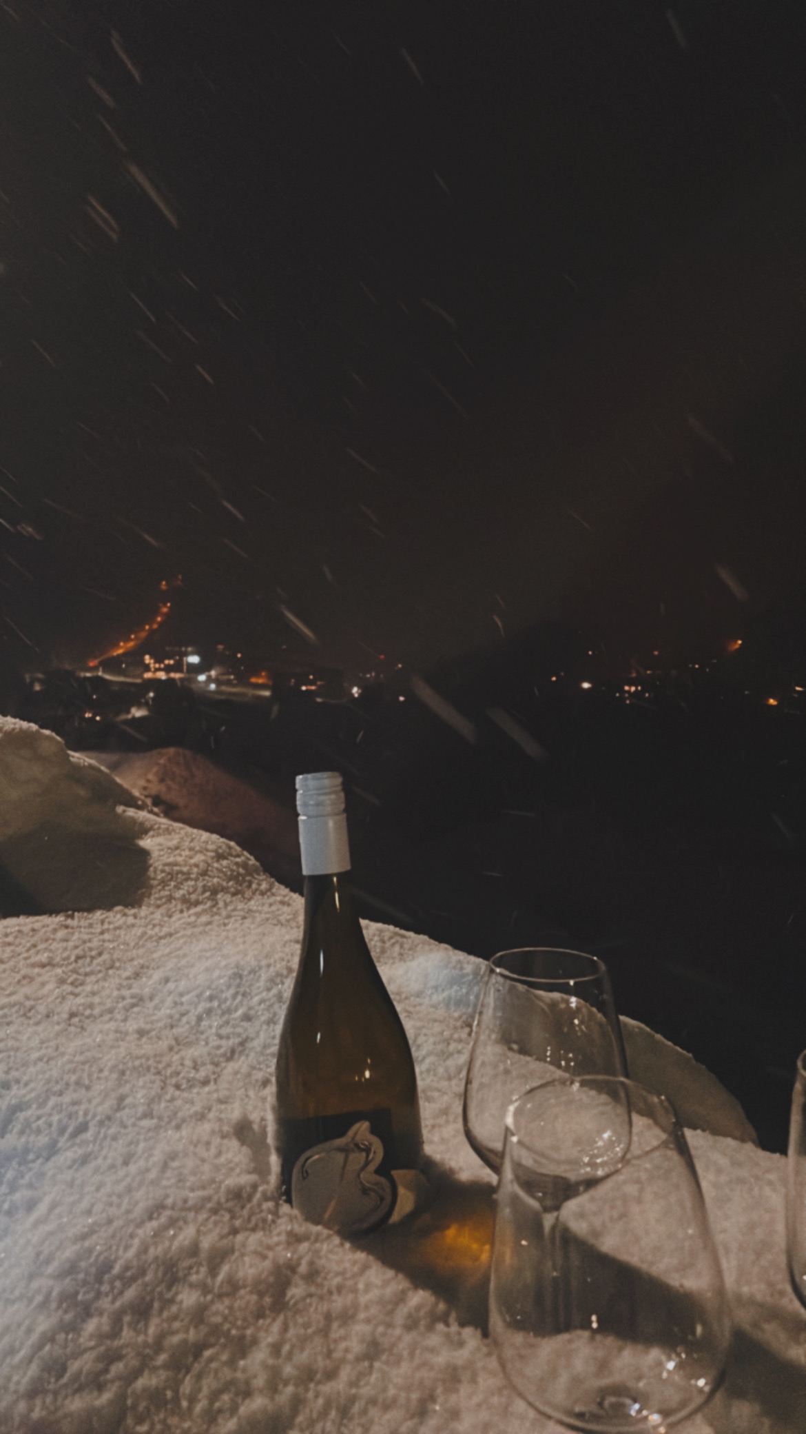 Eine Secco-Flasche und 2 Weingläser im Schnee über Sölden