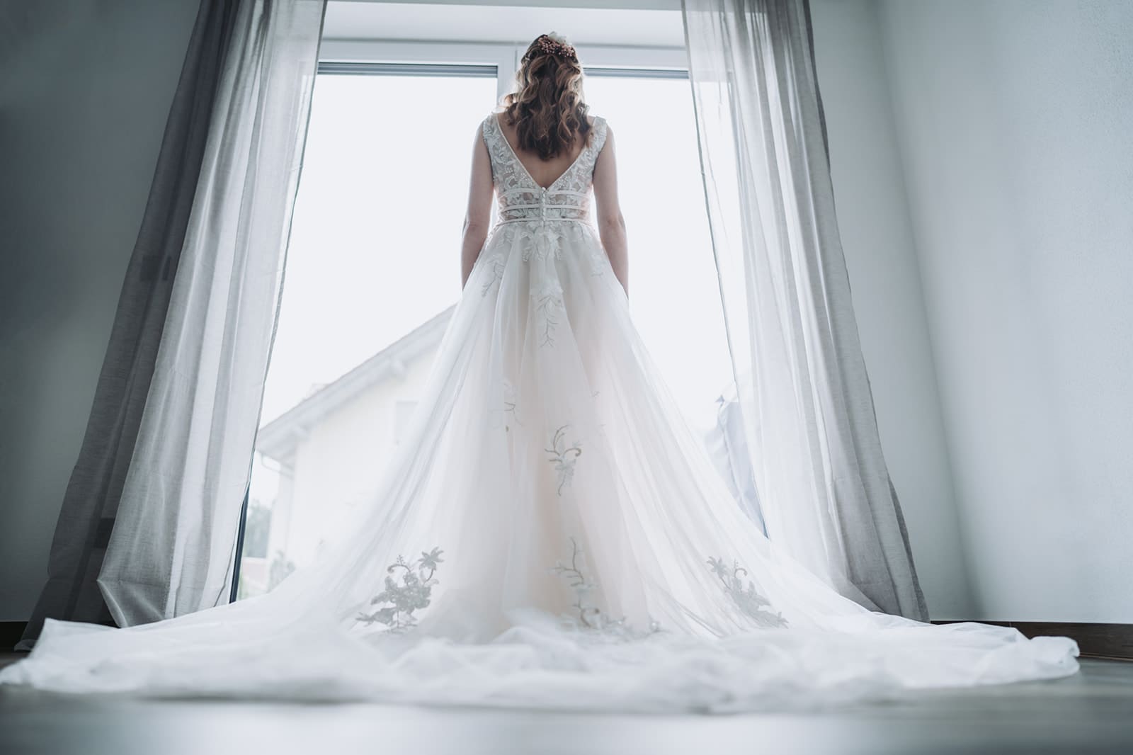 Braut vor einem Großen Fenster fotografiert von hinten in Wörth an der Donau