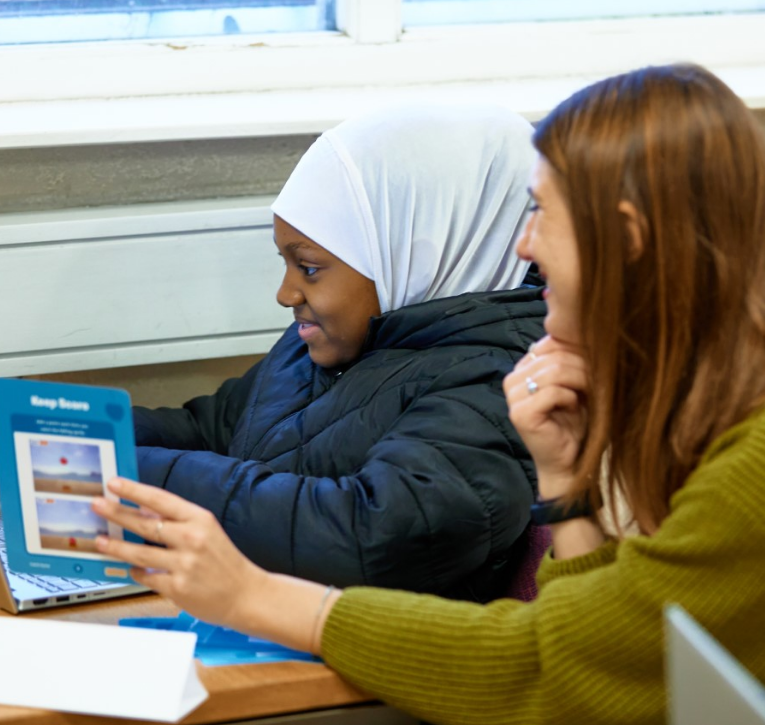 A girl using a laptop receives educational support