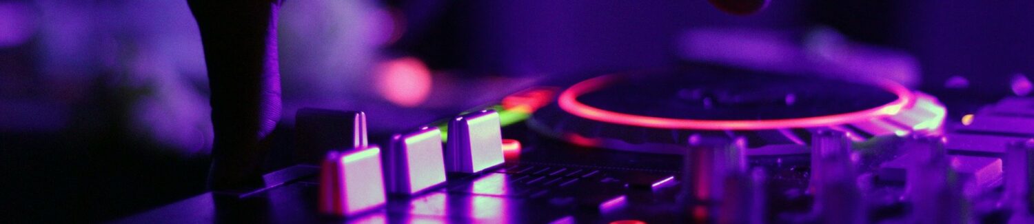 Nahaufnahme eines DJ Mischpult mit bunten Lichtfarben