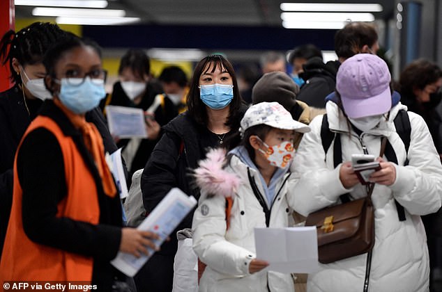 Pictured: Passengers of a flight from China wait in a line for checking their Covid vaccination documents at Charles de Gaulle airport in Paris, France, on Sunday
