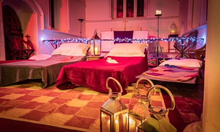 Camp beds and fairy lights inside church