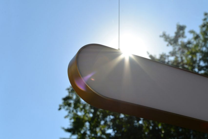 Lamp hung up outside with sun behind it