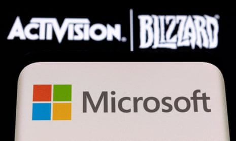 Microsoft logo is seen on a smartphone placed on displayed Activision Blizzard logo.