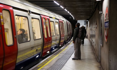 A passenger waits at Westminster underground station as a train arrives at the platform.