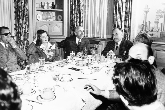 From left, American film director Raoul Walsh, actor Bette Davis, Harry Warner and Jack Warner have lunch at Warner Bros in early 1946