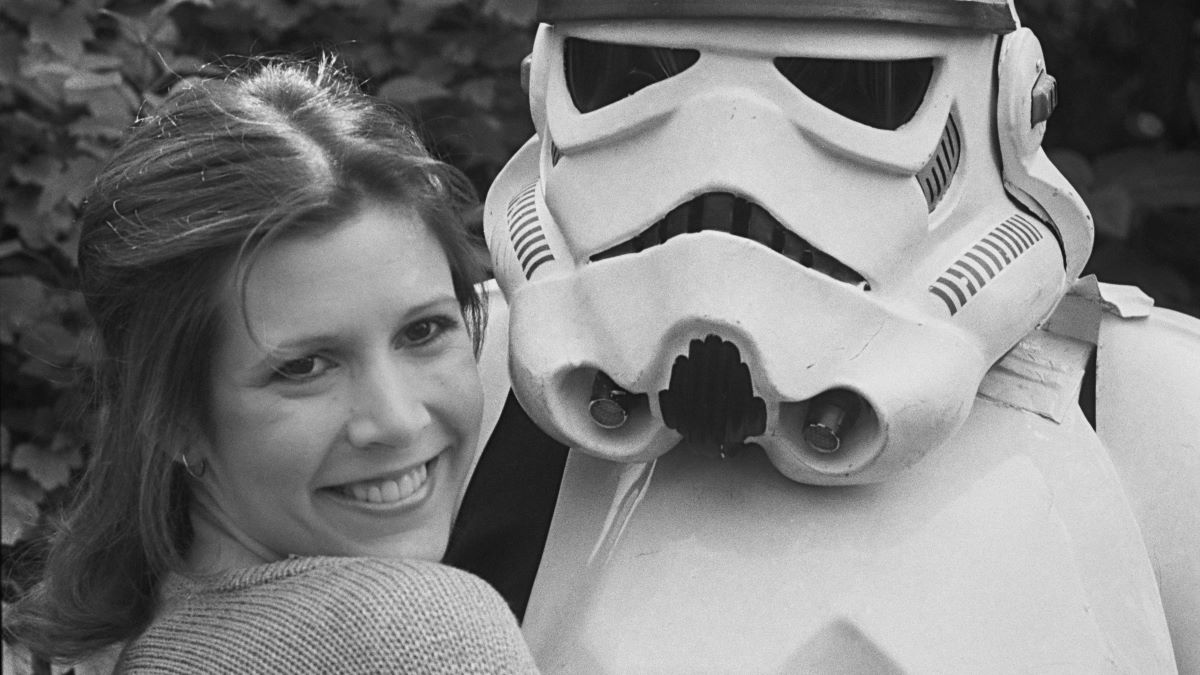 American actress, writer and comedian Carrie Fisher (1956 - 2016) with a Stormtrooper, Star Wars fictional soldier, UK, 20th May 1980. (Photo by Chris Ball/Evening Standard/Hulton Archive/Getty Images)