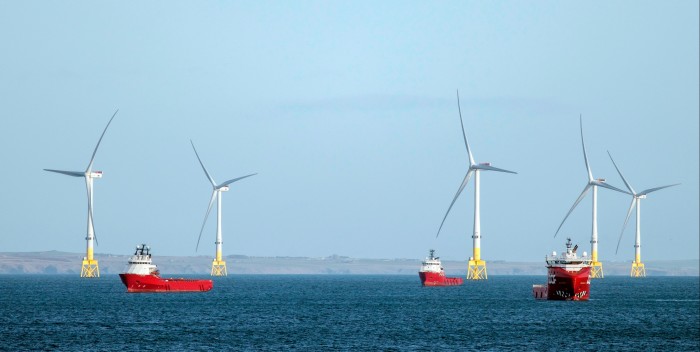 Oil industry supply ships wait near wind turbines off the coast of Aberdeen