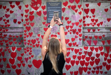 A woman taking a photograph of the plaque on the National Covid Memorial Wall in London today, as the Covid inquiry started the evidence-gathering phase of its hearings.