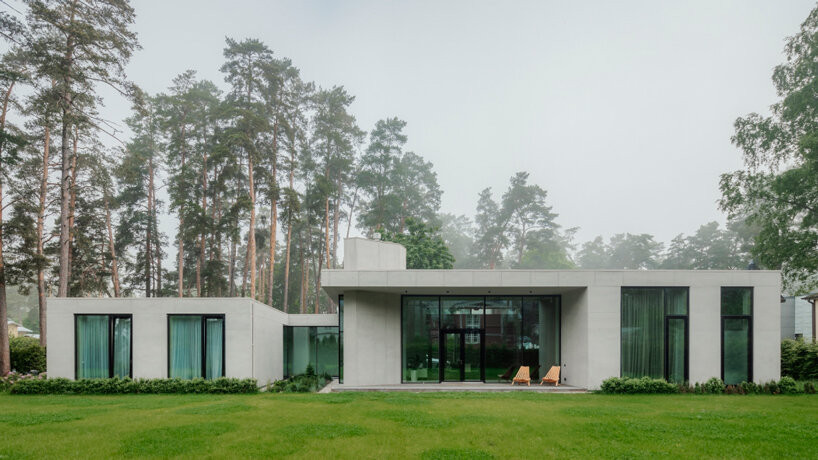concrete residence in latvia unfolds two distinct volumes with dynamic cantilevers