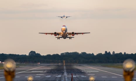 A photograph of the view directly down the runway as an easyJet Airlines plane takes off from Gatwick Airport.
