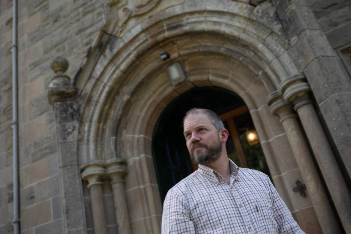 John McCosh stands outside the arched doorway entrance of his main estate home