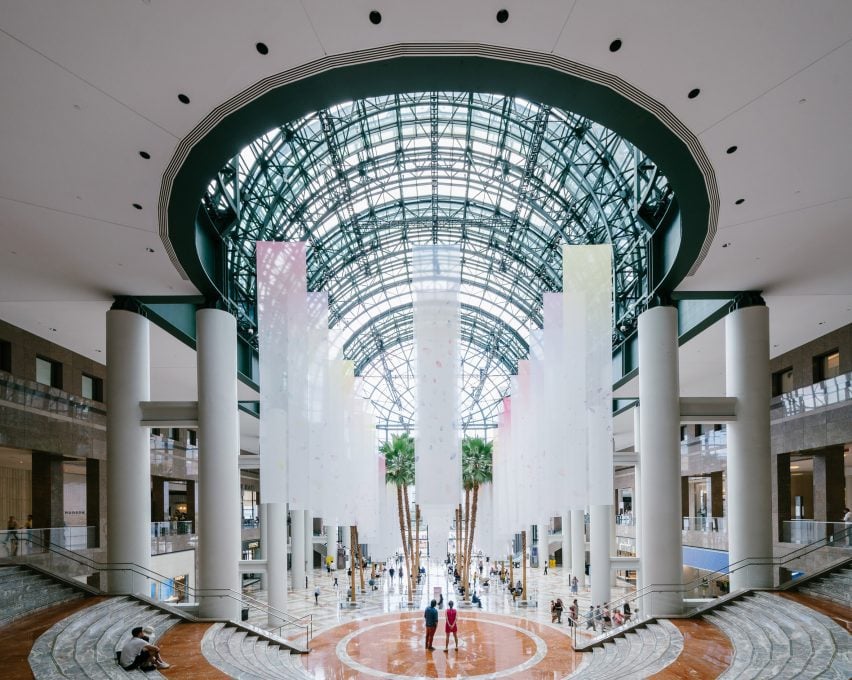 cloth banners hang in the lobby of a glass atrium