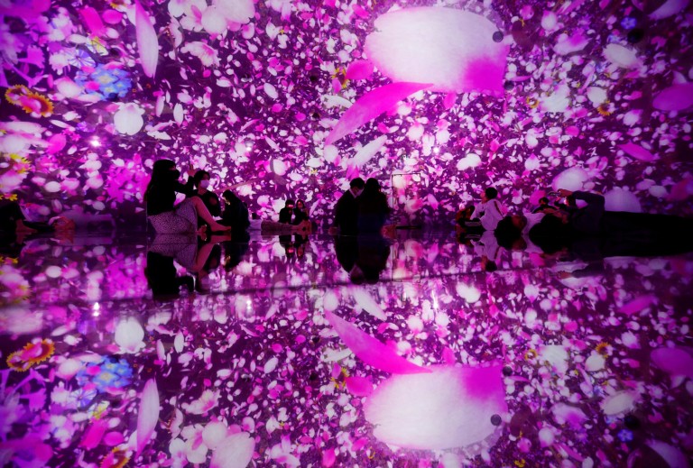 Visitors look at cherry blossom-themed digital artwork celebrating the upcoming spring season at teamLab Planets in Tokyo, Japan, March 1, 2022. REUTERS/Kim Kyung-Hoon