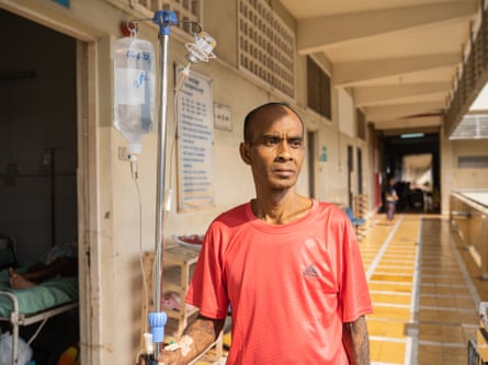 man outside hospital room holding a drip