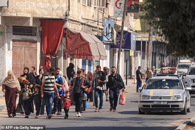 Palestinians with their belongings flee to safer areas in Gaza City after Israeli air strikes, on October 13, 2023