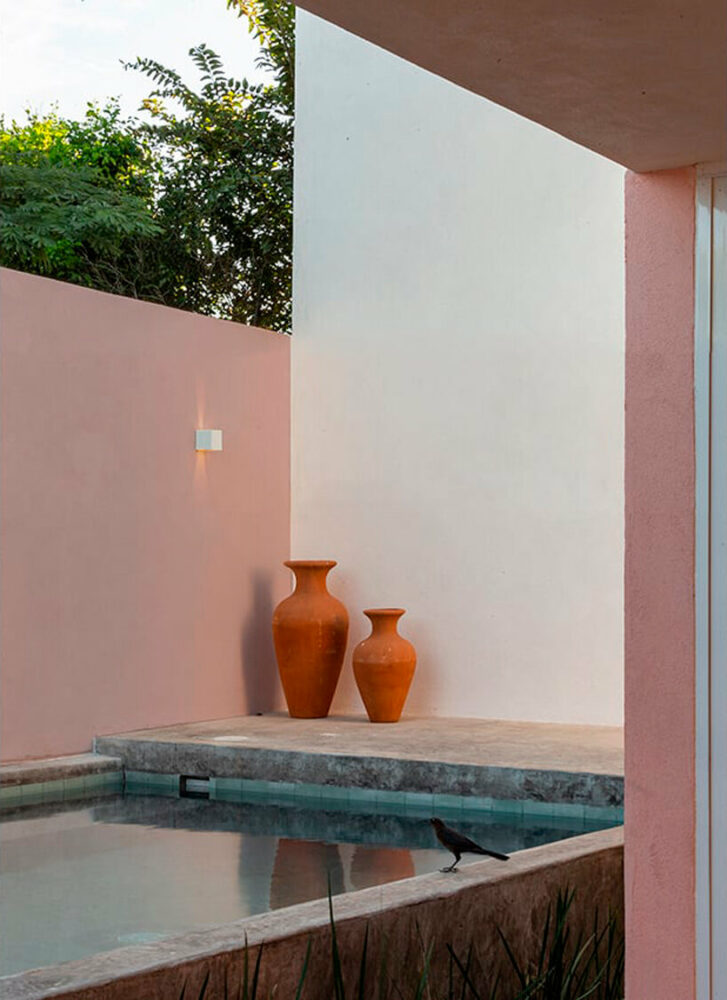 pink-hued sculptural wall emerges as casa banderas' west-facing facade in mexico