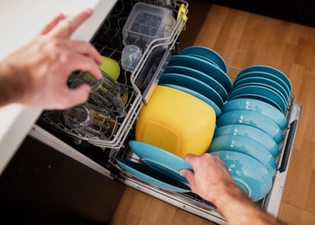 Man arranging dishes in the dishwasher