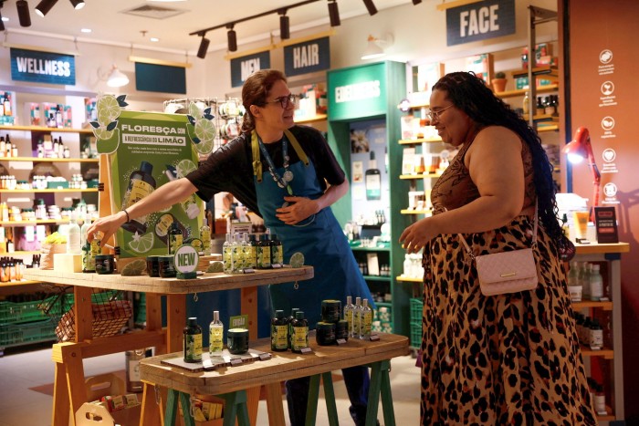 A salesperson and a customer at a Body Shop store