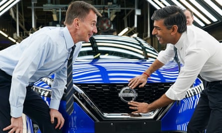 Jeremy Hunt and Rishi Sunak attach a Nissan badge to a car during their visit to the Sunderland plant.