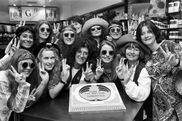 Anita Roddick with other people giving the peace sign