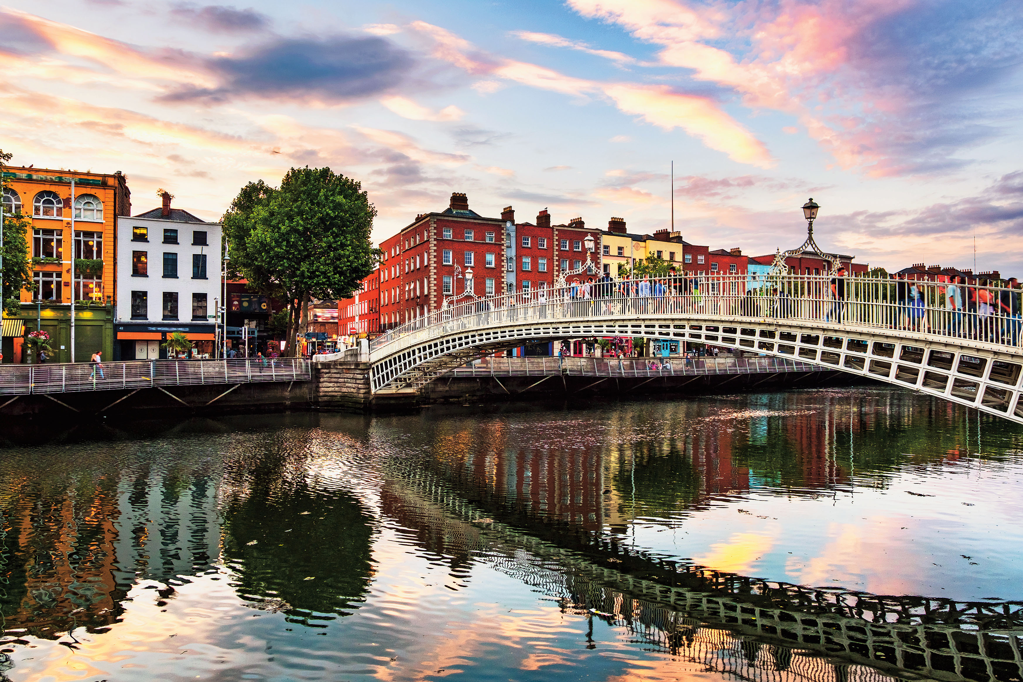 The famous illuminated Penny Bridge in Dublin, Ireland at sunset