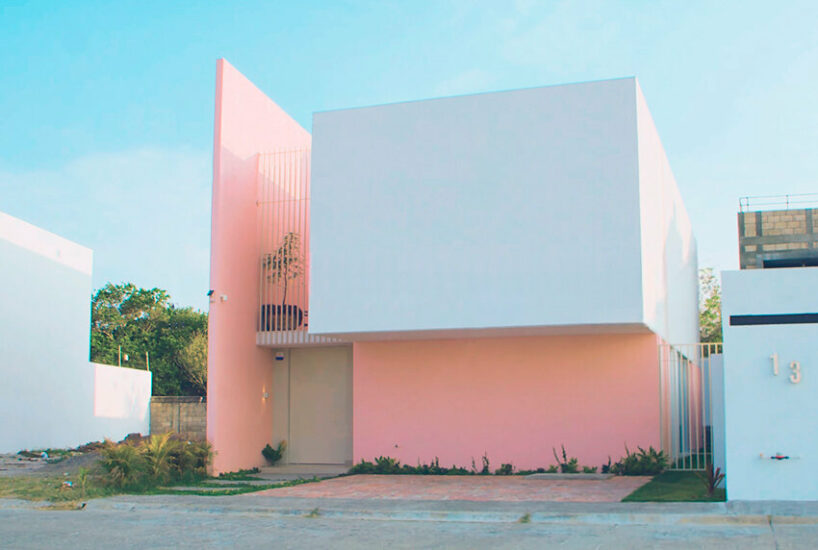pink-hued sculptural wall emerges as casa banderas' west-facing facade in mexico