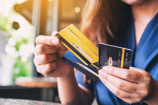 a woman holding and choosing credit card to use