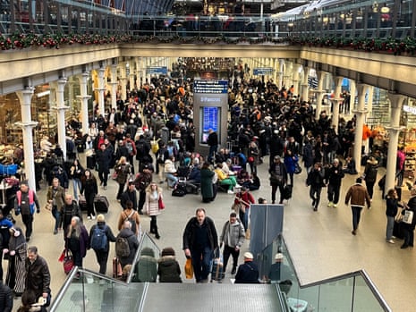 Passengers wait at the Eurostar entrance in St Pancras International station, London. Christmas getaway journeys were ruined for tens of thousands of people on Thursday after cross-Channel rail services were suspended due to an unexpected strike in France